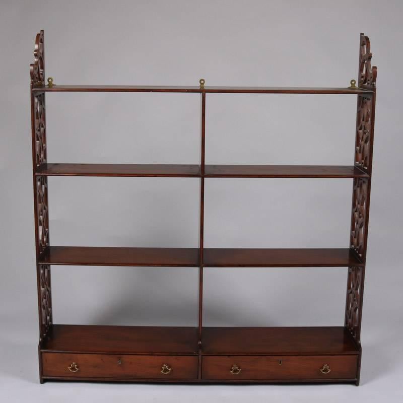 Colonial Williamsburg Restoration mahogany wall shelf by Kittinger features cut-out design sides including upper scrollwork and two lower locking drawers, signed with Kittinger brand stamp on drawer interior, 20th century

Measures: 39