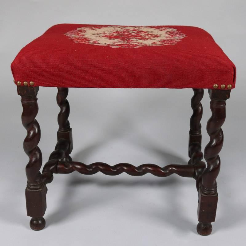 Antique carved mahogany footstool features barley twist legs and stretcher with floral needlepoint cushion, 19th century

Measures: 19" H x 20" W x 16" D.