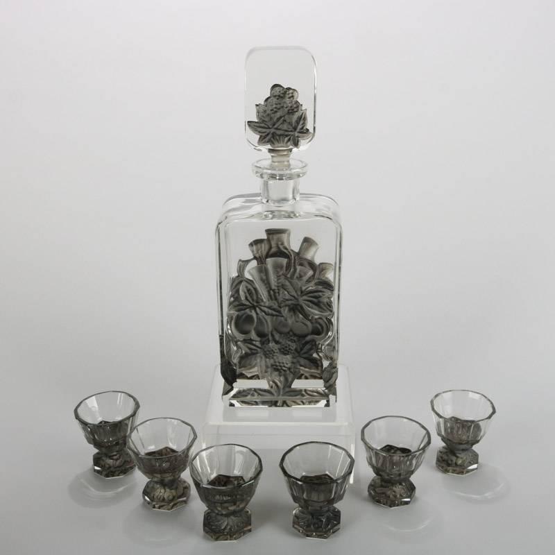Antique French Lalique school liqueur decanter set features molded smoke glass over clear with floral decoration. Set includes decanter and six aperitif goblets, 20th century

Measures: 11.75