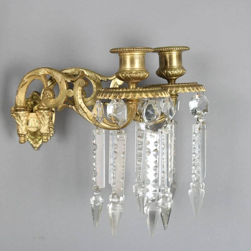 Pair of antique French gilt bronze dual light wall sconces feature scroll and foliate form with "AB" embossed on wall plate, highlighted with cut crystal prisms, 19th century

Measure: 8" H x 15" W x 10" D.