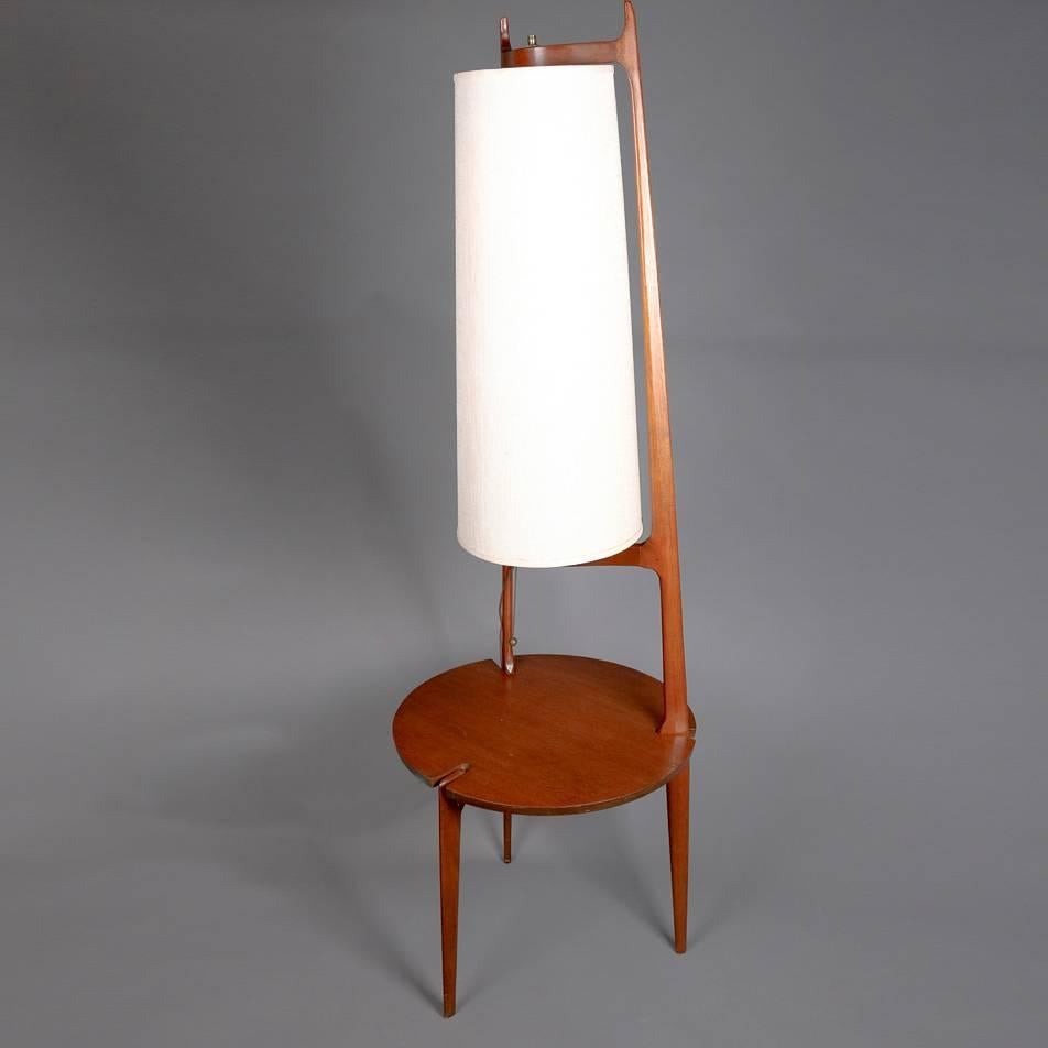 Midcentury Danish Modern floor lamp features teak tripod frame with conical form shade with incorporated side stand/table, mid-20th century

Measures: 66" H x 21" tbl.