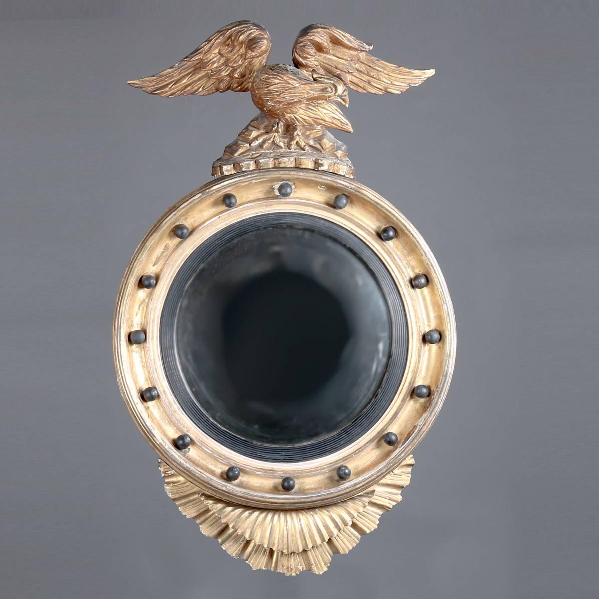 Antique Federal giltwood bullseye wall mirror features spread eagle crest and stylized fanned tail feather apron, ebonized highlights, 19th century

Measures - 38