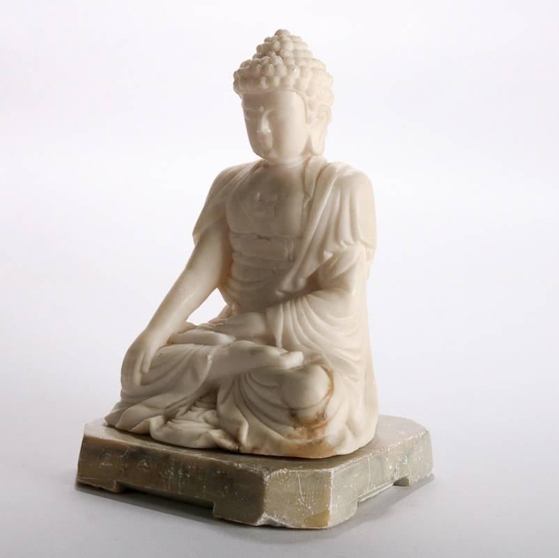 Antique carved marble Bhumisparsha Mudra Buddha (earth touching or witness buddha) with swastika, the Hinduism clockwise symbol symbolizing surya (sun) and prosperity, chop marks inscribed on base face, 19th century

Measures: 9