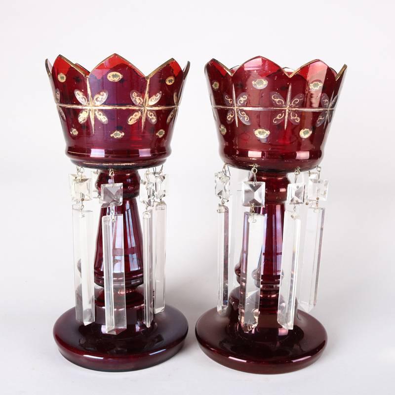 Pair of antique cut cranberry glass mantel lusters feature scalloped bowl with floral gilt decoration and hanging cut crystal prisms, 19th century

Measures: 12" H, 5.5" OP, 5.75" BS (W).