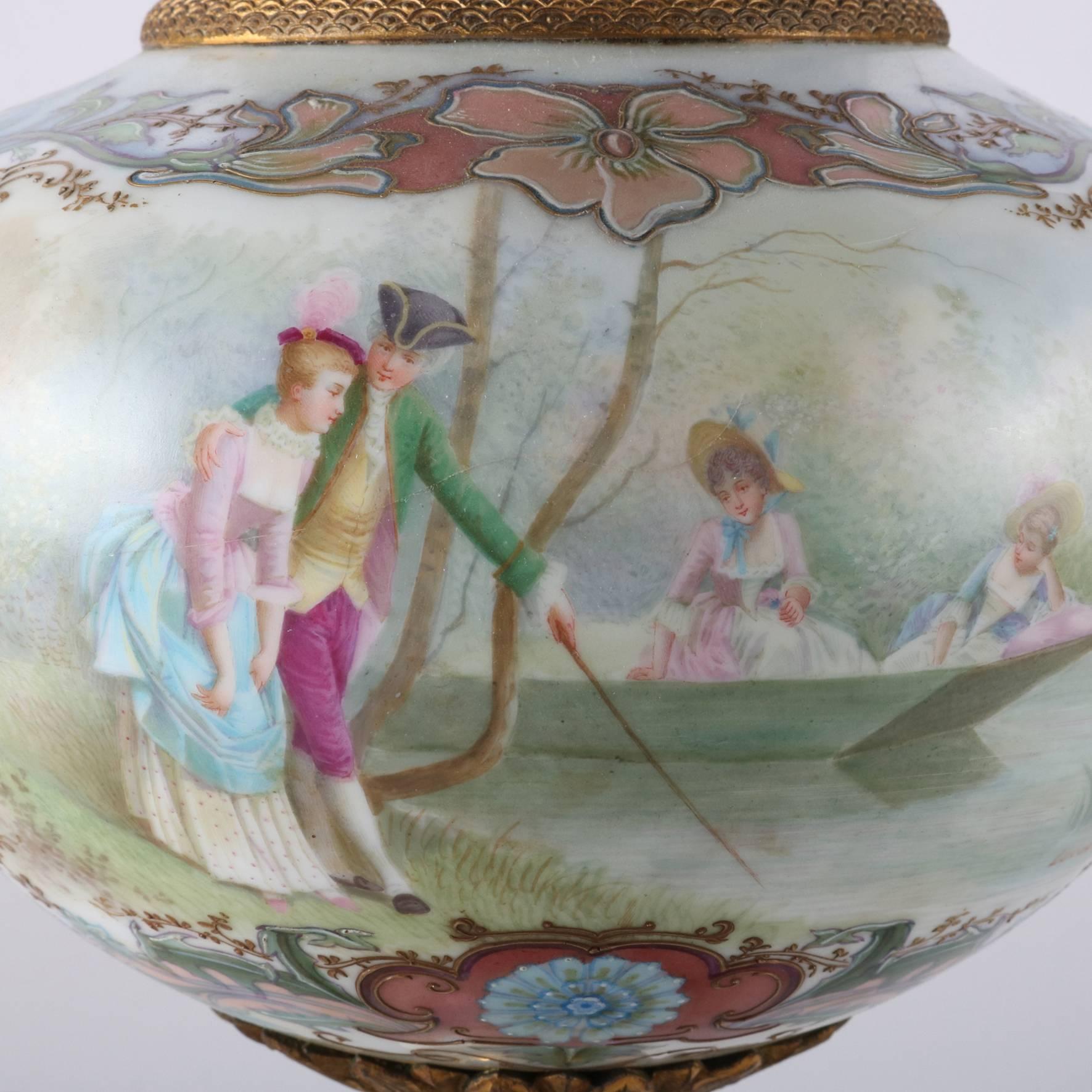 Antique French Sèvres porcelain urn features hand-painted reserve of countryside scene with courting couples signed Lucot, floral and gilt decoration, and cast bronze footed base, acorn finial and trim, 19th century

Measures: 19