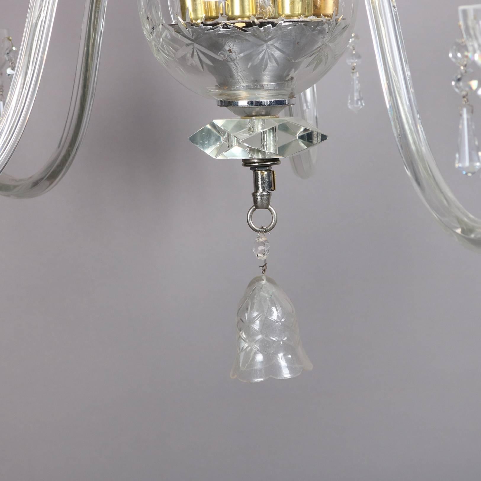 Oversized European crystal chandelier features pressed glass bodice and ten scroll arms terminating in candle lights, cut-glass prism highlights, 20th century


Measures: 48