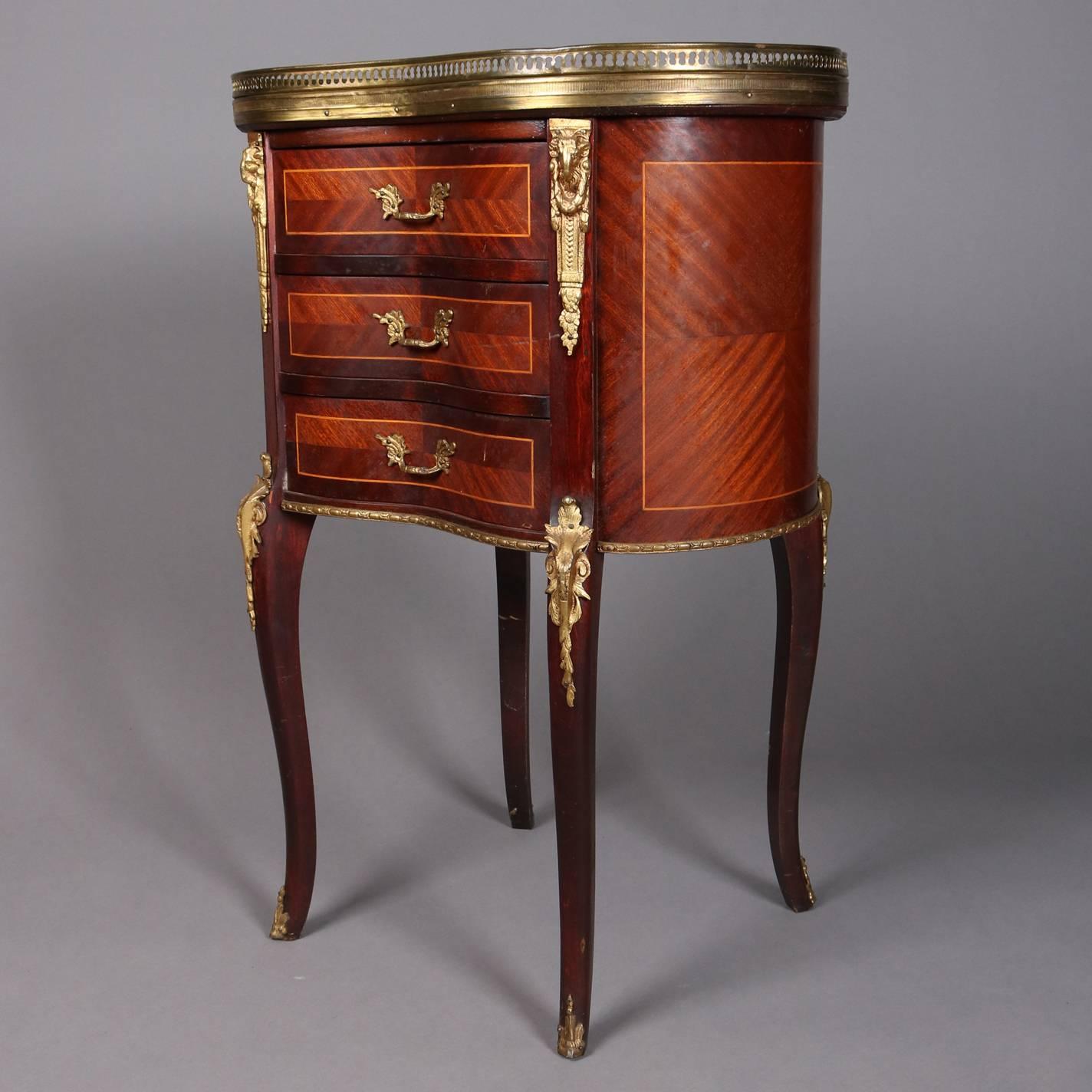 Antique French Louis XV mahogany and rosewood stand features kidney form, three drawers with bookmatched and inlaid panels and satinwood banding, ormolu accoutrements and pierced gallery, seated on cabriole legs, 19th century

Measures: 29