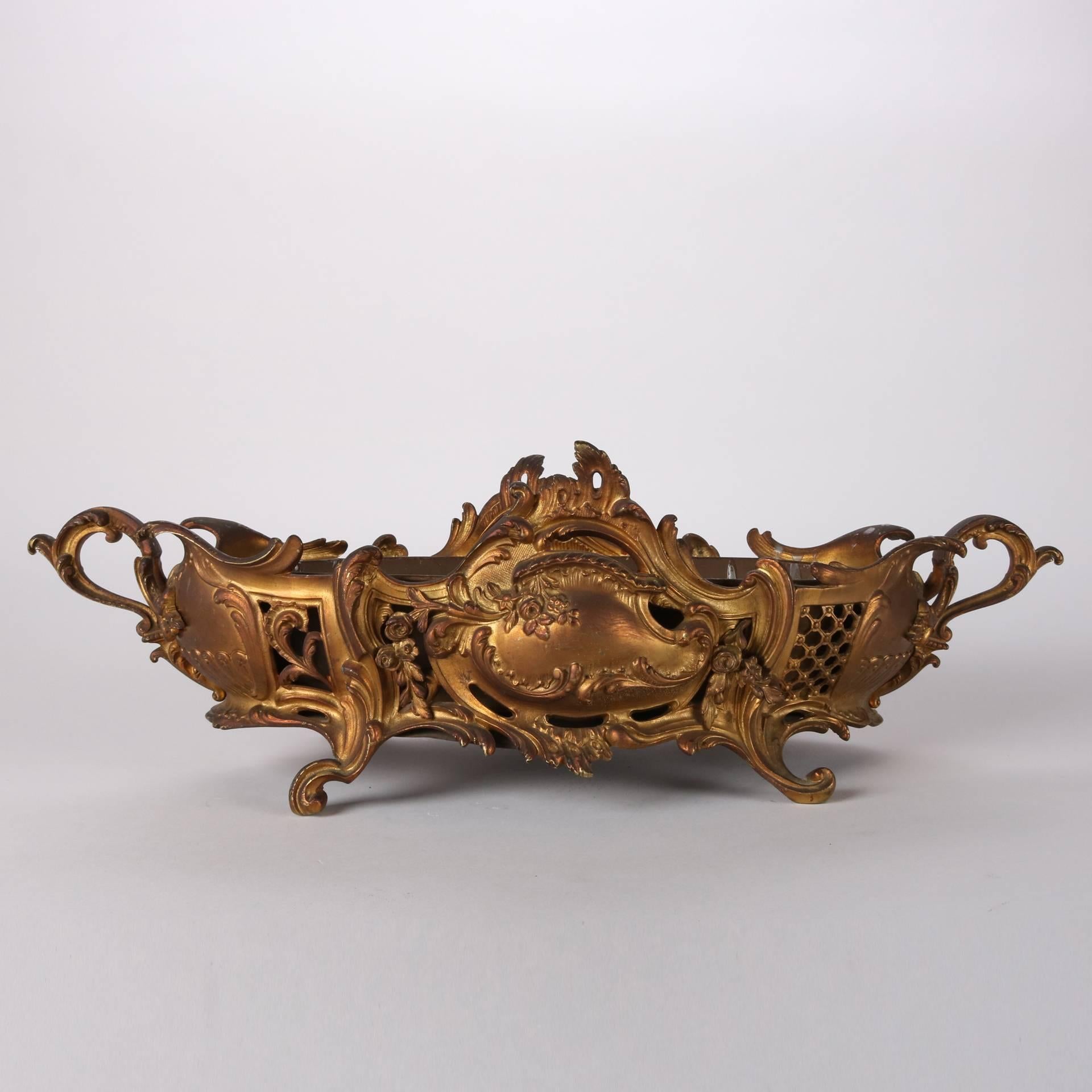 Antique French Rococo double handled console bowl feature pierced gilt bronze frame with scroll, floral and foliate decoration, solid insert, seated on four scrolled feet, 19th century

Measures: 6