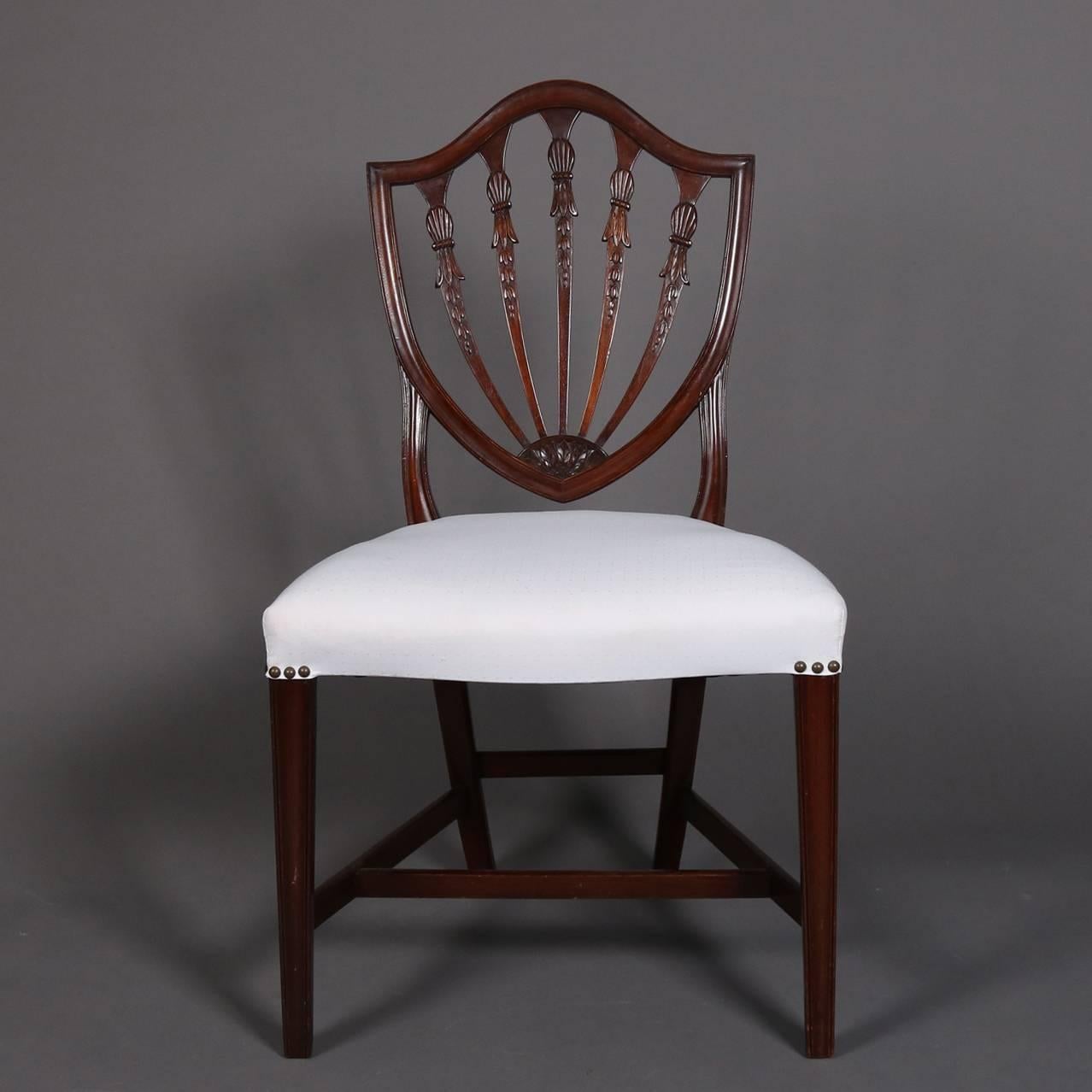 Set of six antique Federal mahogany shield back dining chairs feature carved tassel, inverted bellflowers and acanthus leaves, upholstered seats, 20th century.

Measure - 37.5"H X 21"W X 18"D, 17" seat height.
