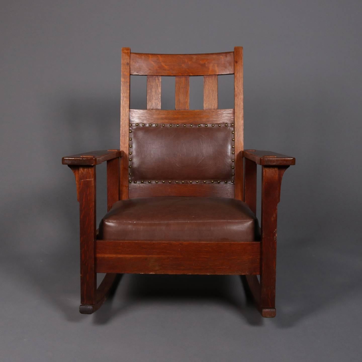 Antique Arts & Crafts Mission oak Stickley Brothers rocking chair features back with slat upper and upholstered lower and upholstered seat, signed Stickley Bros. on underside, circa 1910

Measures: 33