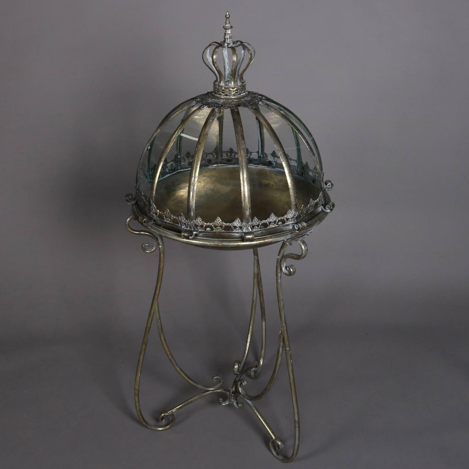 Hollywood Regency terrarium features scrolled metal stand with bowl supporting royal form domed glass cover reminiscent of king's crown, 20th century

Measures - 48
