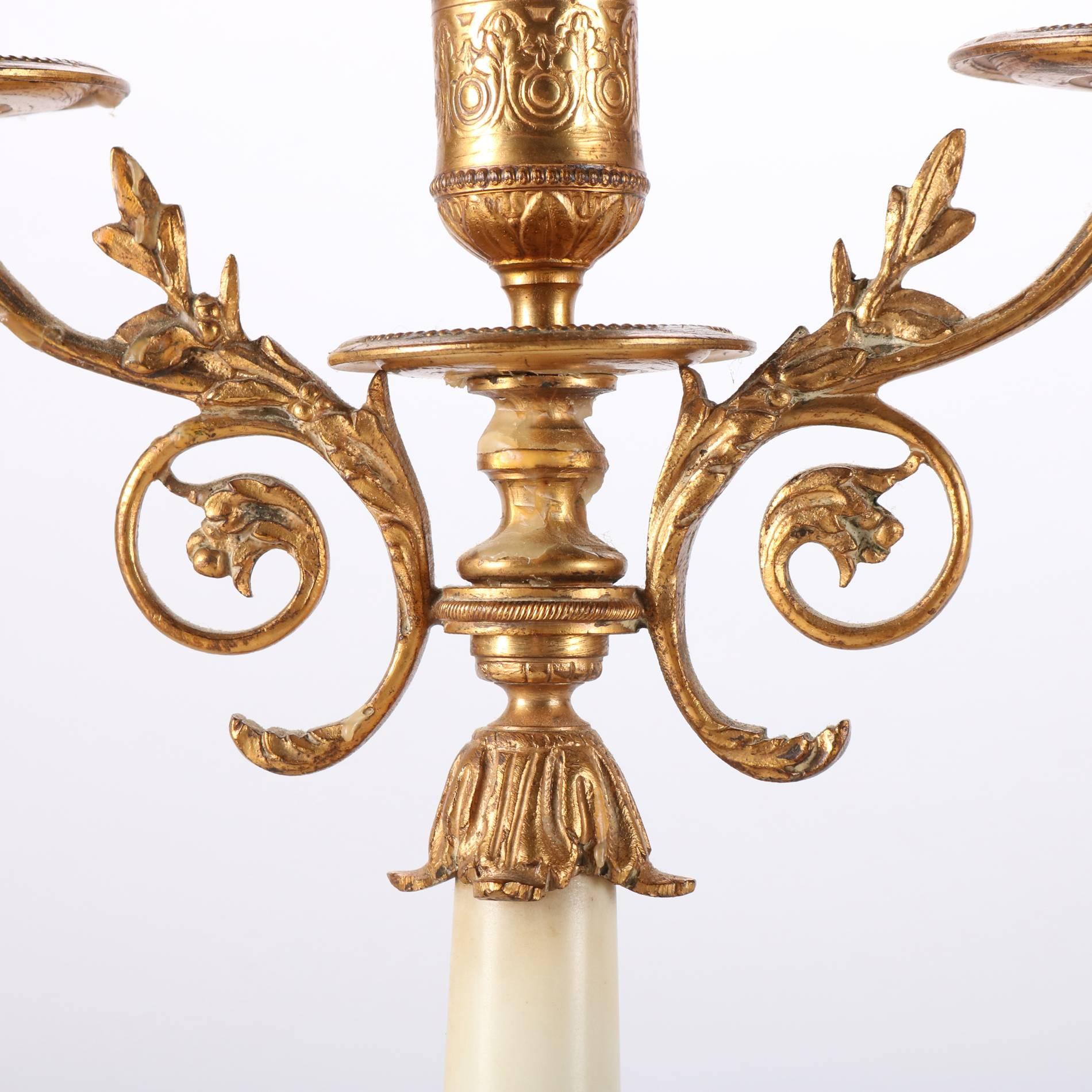 Pair of antique French gilt bronze classical candelabra feature three scroll and foliate form arms terminating in candle receivers, marble column and base each seated on four gilt bronze feet, 20th century

Measure: 12