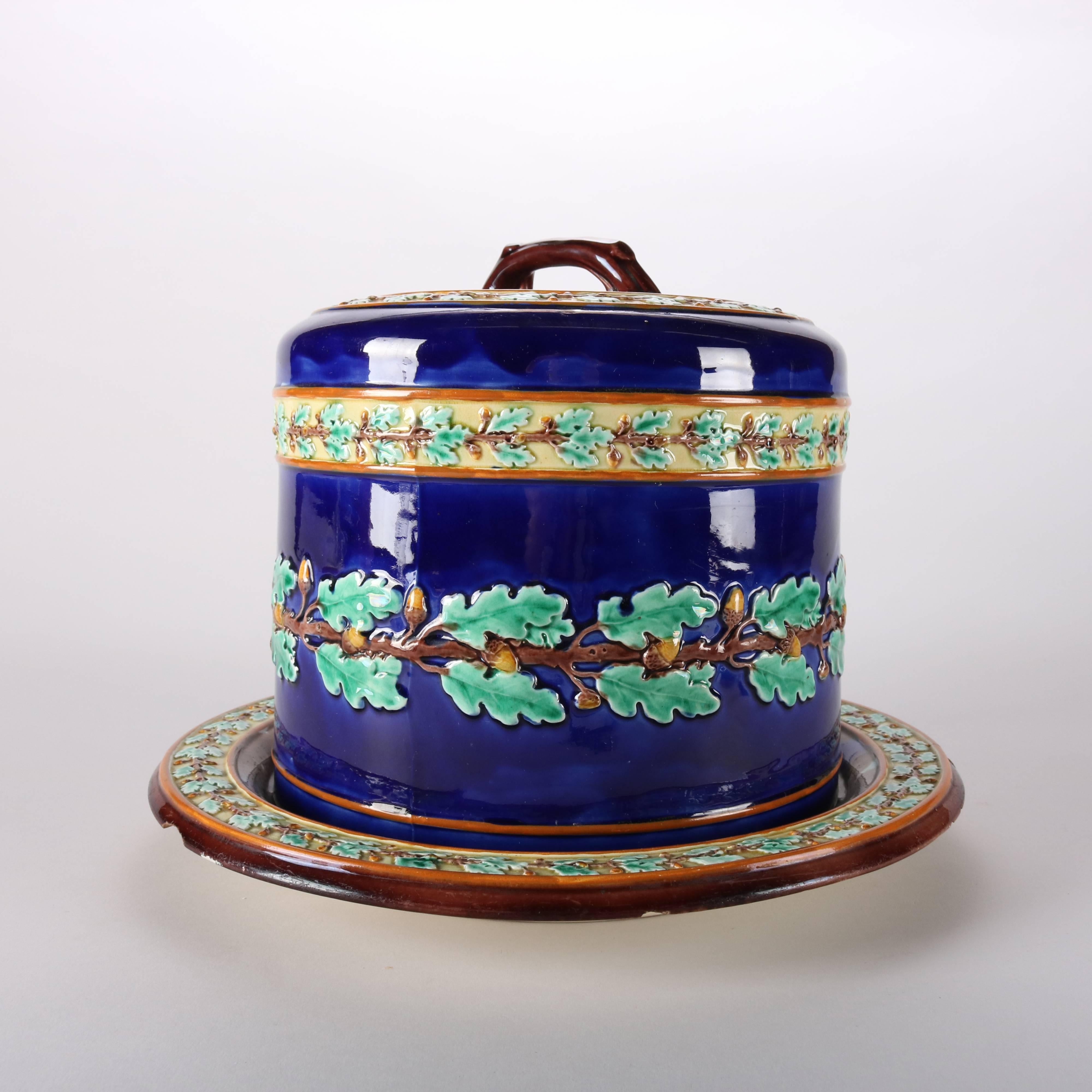 Antique English Majolica pottery cheese keeper and under plate by Wedgwood features oak leaf and acorn pattern on cobalt blue ground, maker mark on base, 20th century.

Measures: 9.5
