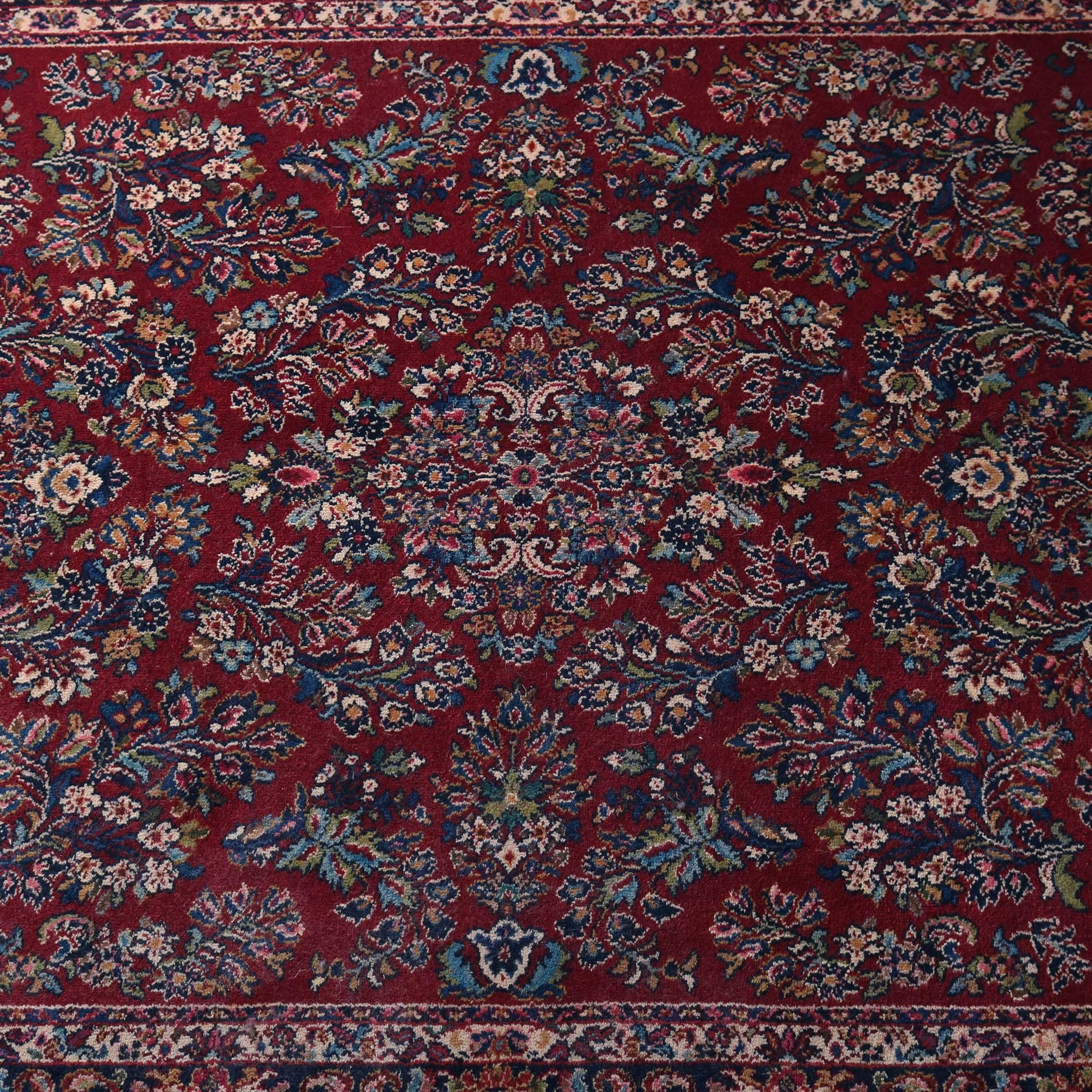 Vintage Persian style Oriental rug by Karastan features detached floral spray pattern with central medallion on red ground, wool, original tag "Red Sarouk” design 785", 5'9" x 9", 20th century

Measures - 5'9" x 9'.