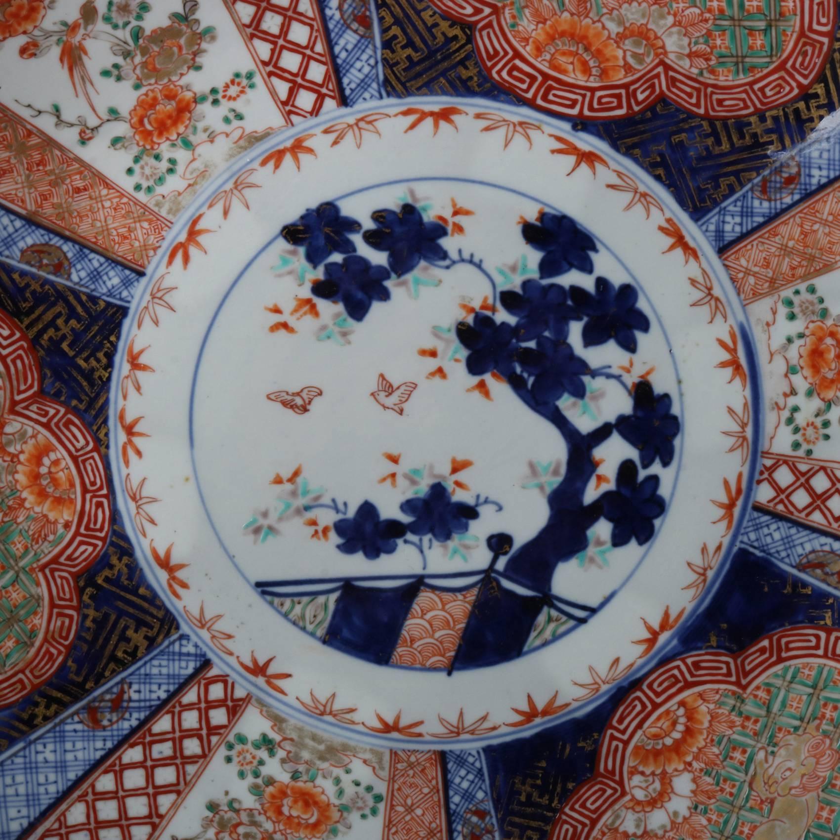 Antique Japanese Imari porcelain charger plate features hand painted and gilt central Bonsai tree, border with reserves of Asian animal figures and flowers, en verso blue decorated, 20th century

Measures - 15.5"diam x 2.5"h