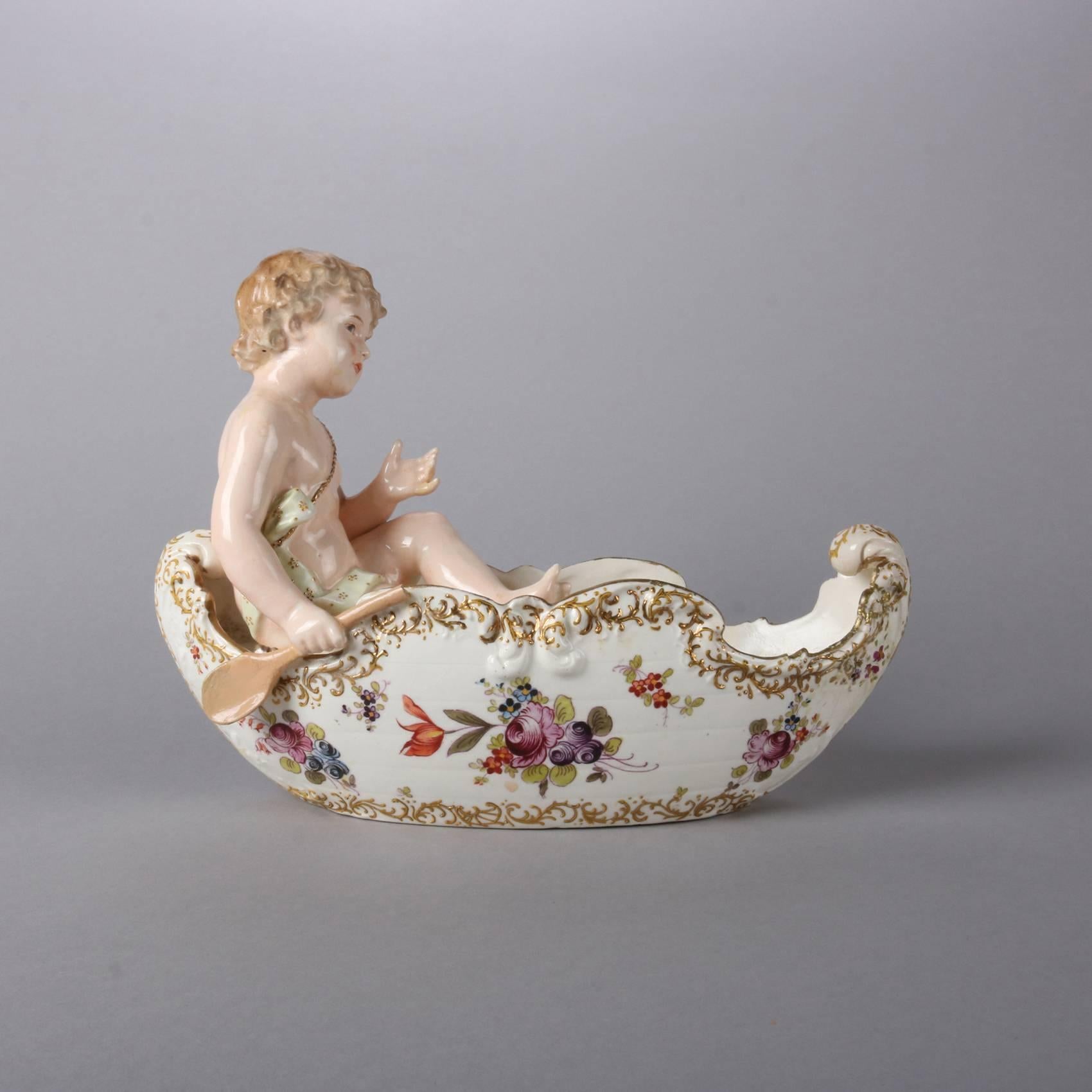 Antique German Meissen School figural porcelain center bowl features cane form with hand painted floral decoration with gilt embossed scroll and foliate decoration and young boy with his paddle, 19th century

Measures: 8.5" H x 11" W x