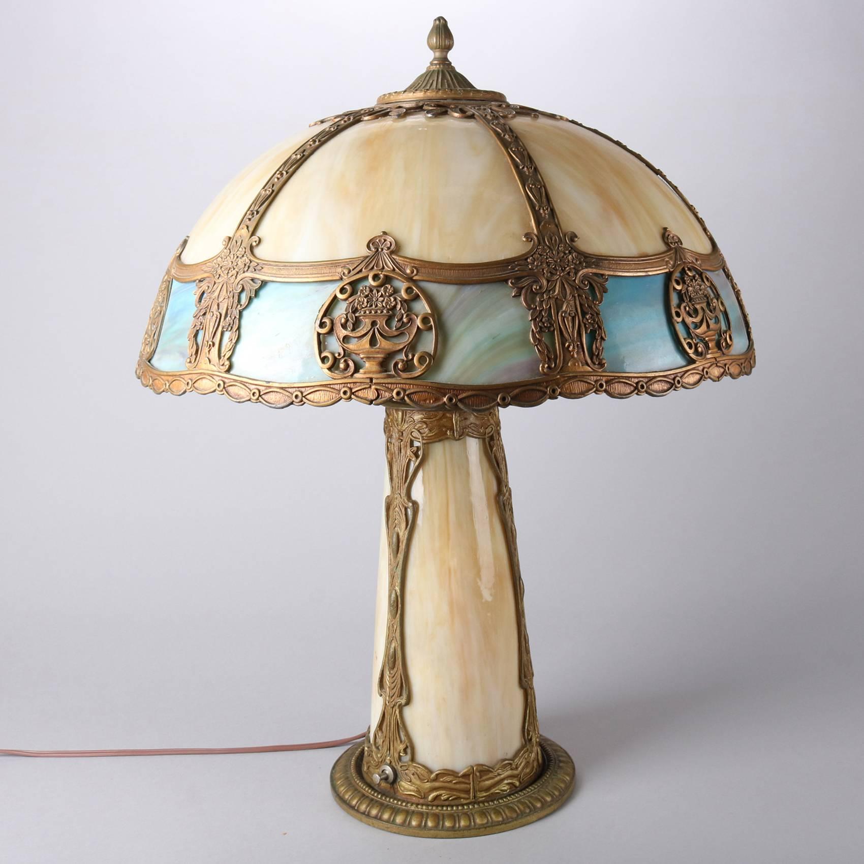 Antique Arts & Crafts Mission style Miller school lamp features urn form filigree six panel shade with independently controlled lighted base, newly rewired, early 20th century

Measures- 24
