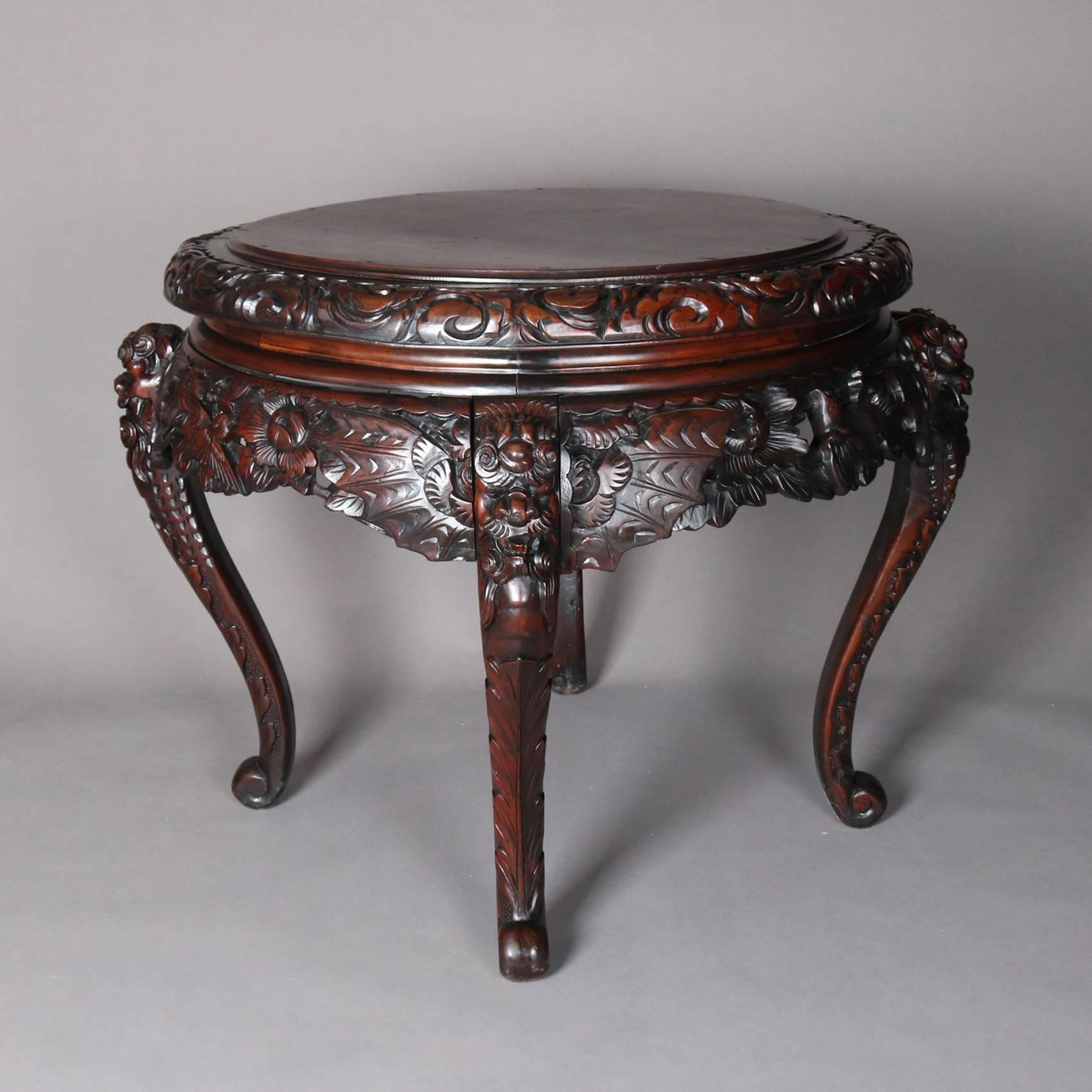 Antique Japanese carved hardwood figural centre table features carved and pierced apron, floral and foliate with birds, and figural legs, 19th century.

Measures: 33" height x 38" diameter.