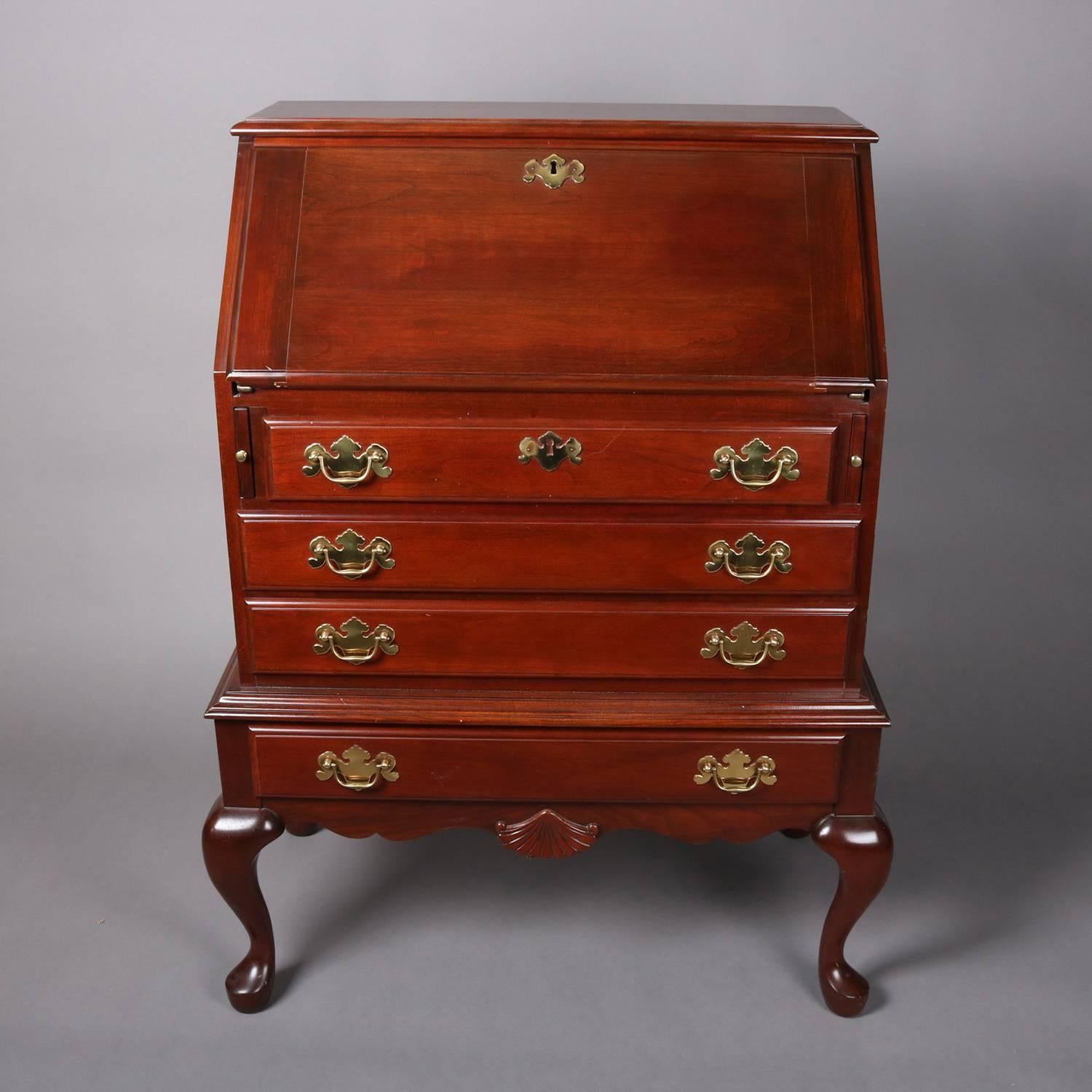 Vintage Queen Anne Baker style secretary by The Colonial Furniture Company features cherry construction with drop front writing surface opening to interior pigeon holes and storage compartments, four drawers, seated on cabriole legs, and having