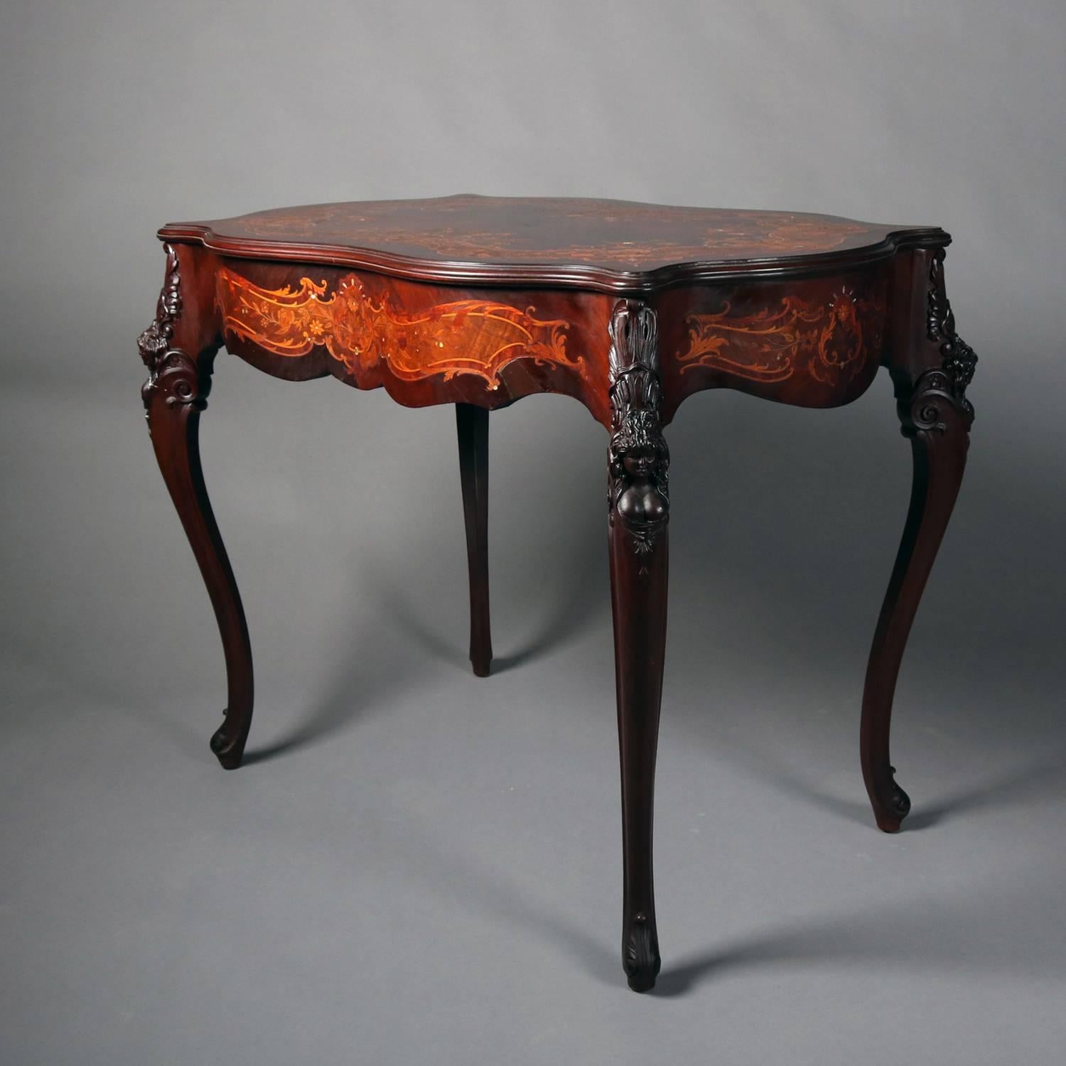 Antique French Louis XV center table features carved mahogany construction with satinwood and mother of pearl floral marquetry inlay, scalloped edges and seated on carved cabriole legs, 19th century

Measures - 30