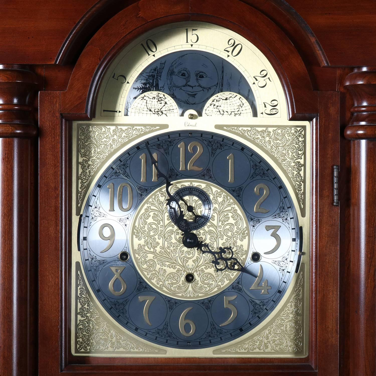 Vintage tall case clock by Colonial Molyneux features mahogany case with flanking columns and moon phase face, three key wind and three weight movement, in working condition, chimes on the quarter hour with hour count, Serial #8405721, original
