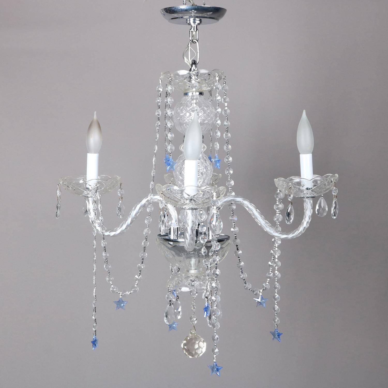 French style chandelier features crystal bodice with four glass arms terminating in candle lights, strung crystals throughout and highlighted with sapphire blue star cut crystals, 20th century

Measures - 25.25" drop from canopy x 22"diam