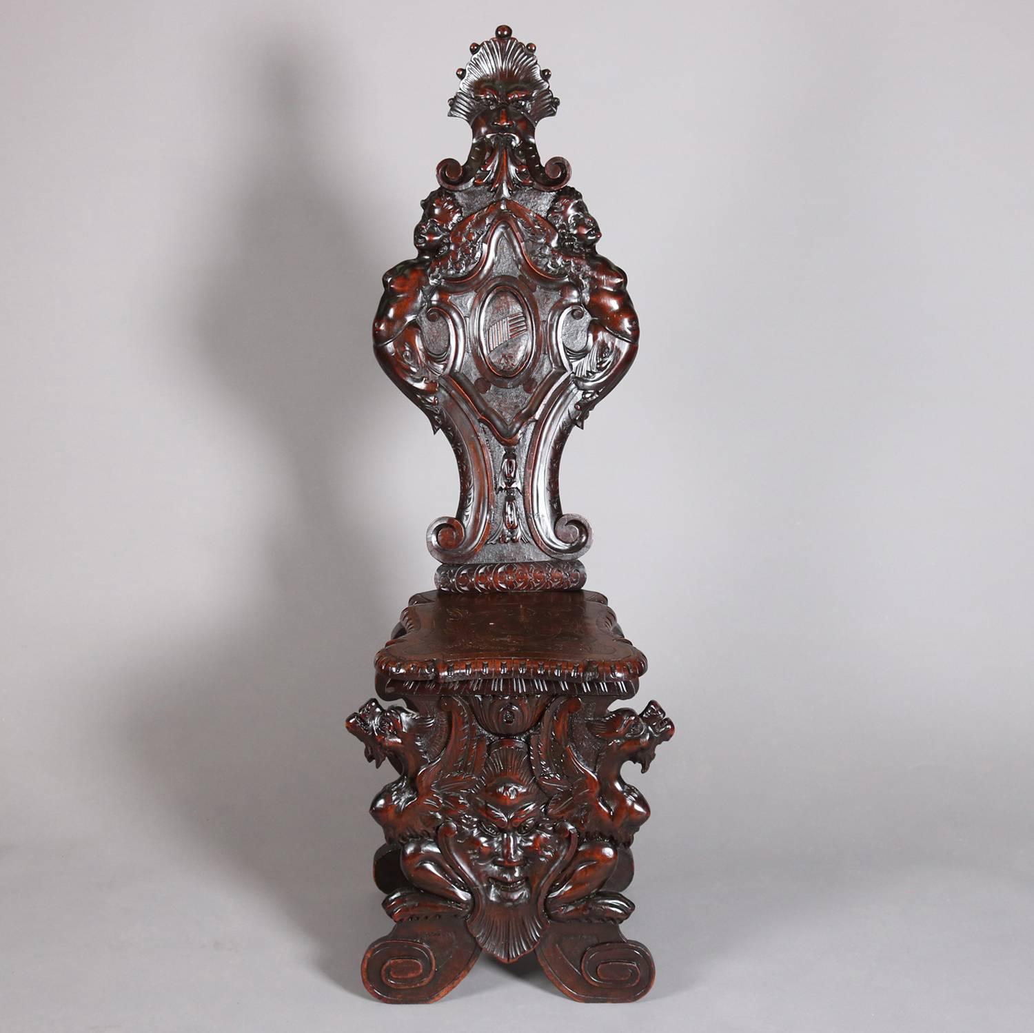 Antique Italian Renaissance heavily carved figural walnut hall chair features cherubs, dragons and Wind God masks with scroll decoration throughout, shaped back with central shield, 19th century

Measures - 56.5