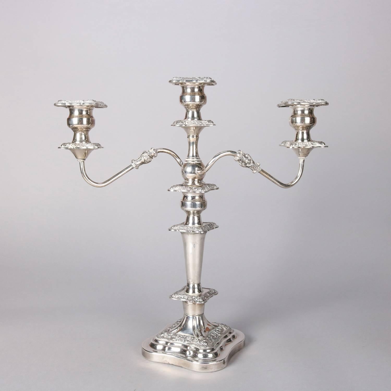 Pair English antique Victorian silver plate candelabra feature floral embossing, each with pair of scroll arms terminating in candle receivers flanking central candle, crown hallmark on base, c1900

Measure - 18