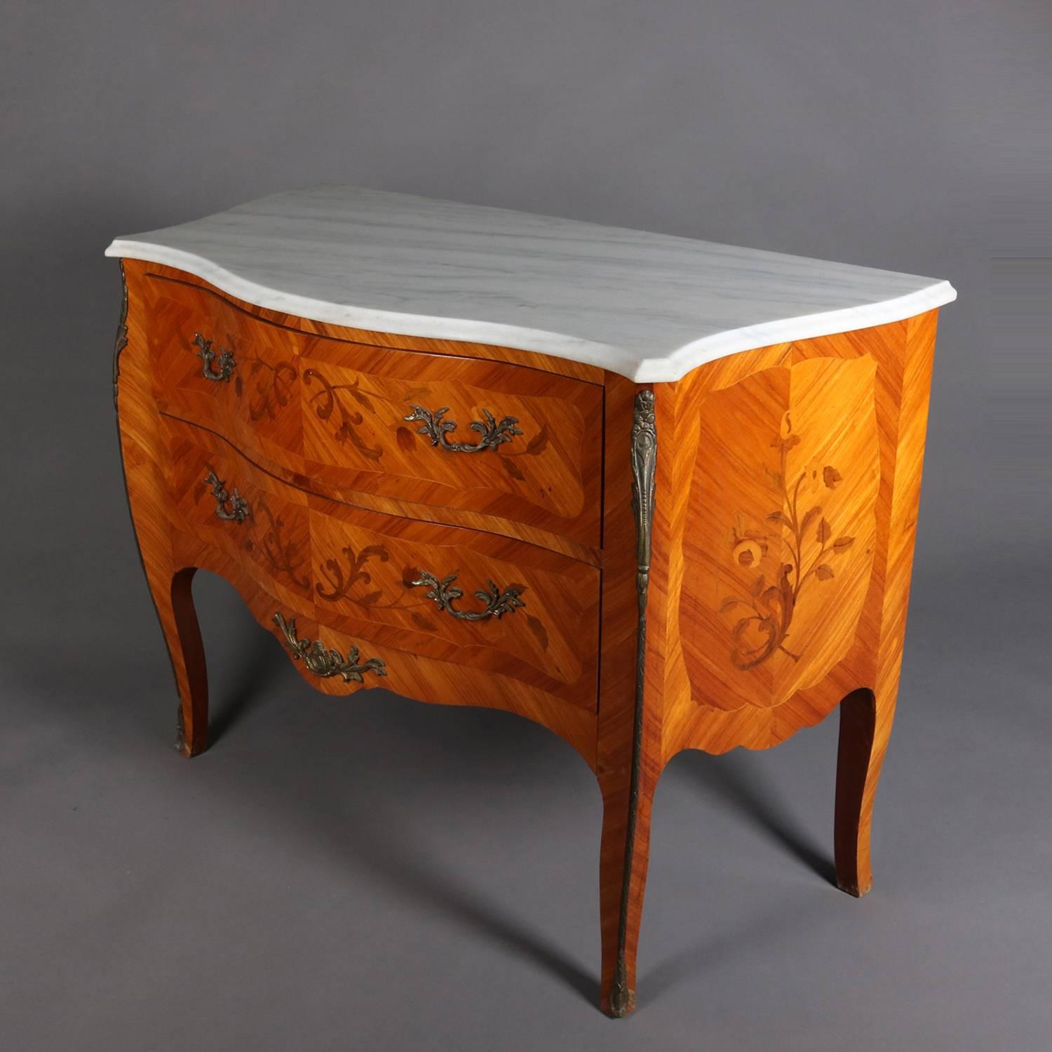 French Louis XVI style two drawer commode features bookmatched mahogany facing with floral satinwood inlaid design, foliate form cast ormolu mounts, and shaped marble top, c1900

Measures - 33