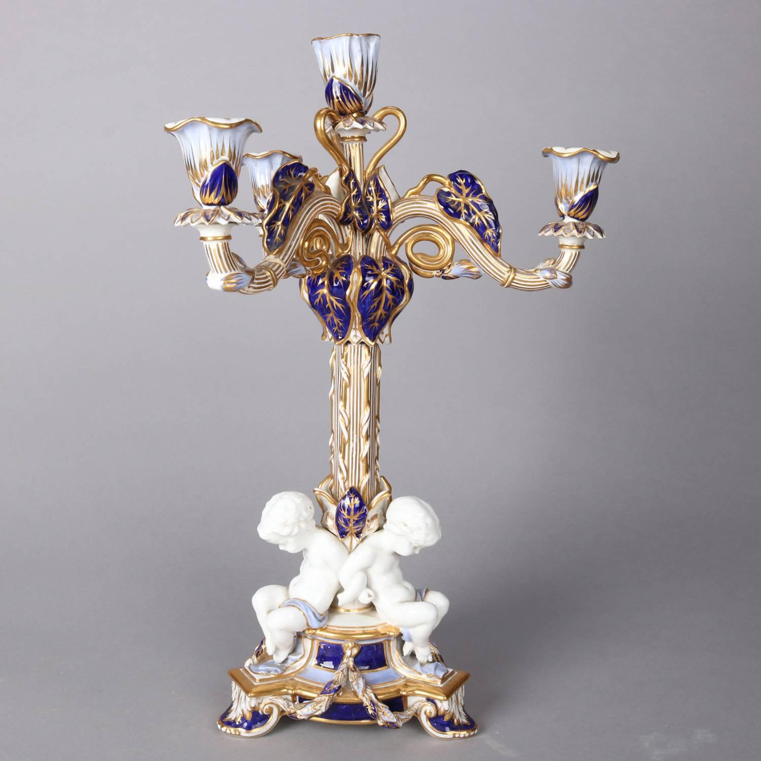 Pair of Meissen school porcelain four light figural candelabra feature hand painted cobalt and gilt foliate form with cherubs seated at base, 20th century

Measures: 18