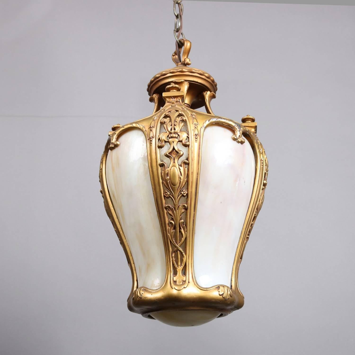 Neoclassical hanging pendant light features pierced foliate and scroll gilt frame with slag glass panels, 20th century

Measures: 33