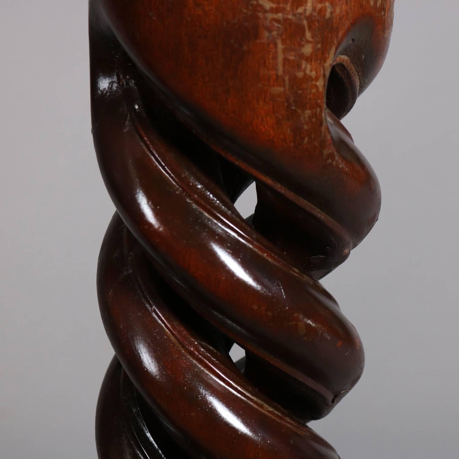 Pair of neoclassical mahogany display pedestals feature heavily carved open barley twist shaft with carved palmette and egg-and-dart at headers and footers, 20th century

Measure: 42