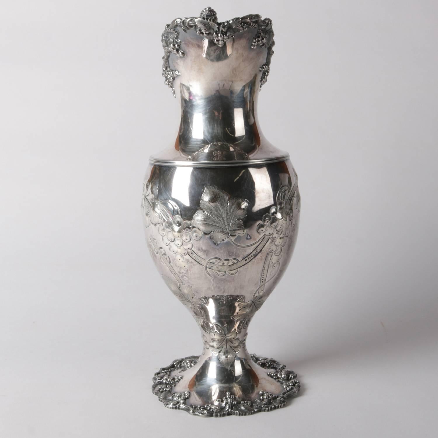 Victorian silver plate ewer (water pitcher) by Barbour Silver Co. features embossed foliate decoration on lip and foot, engraved orchid decoration on body with 