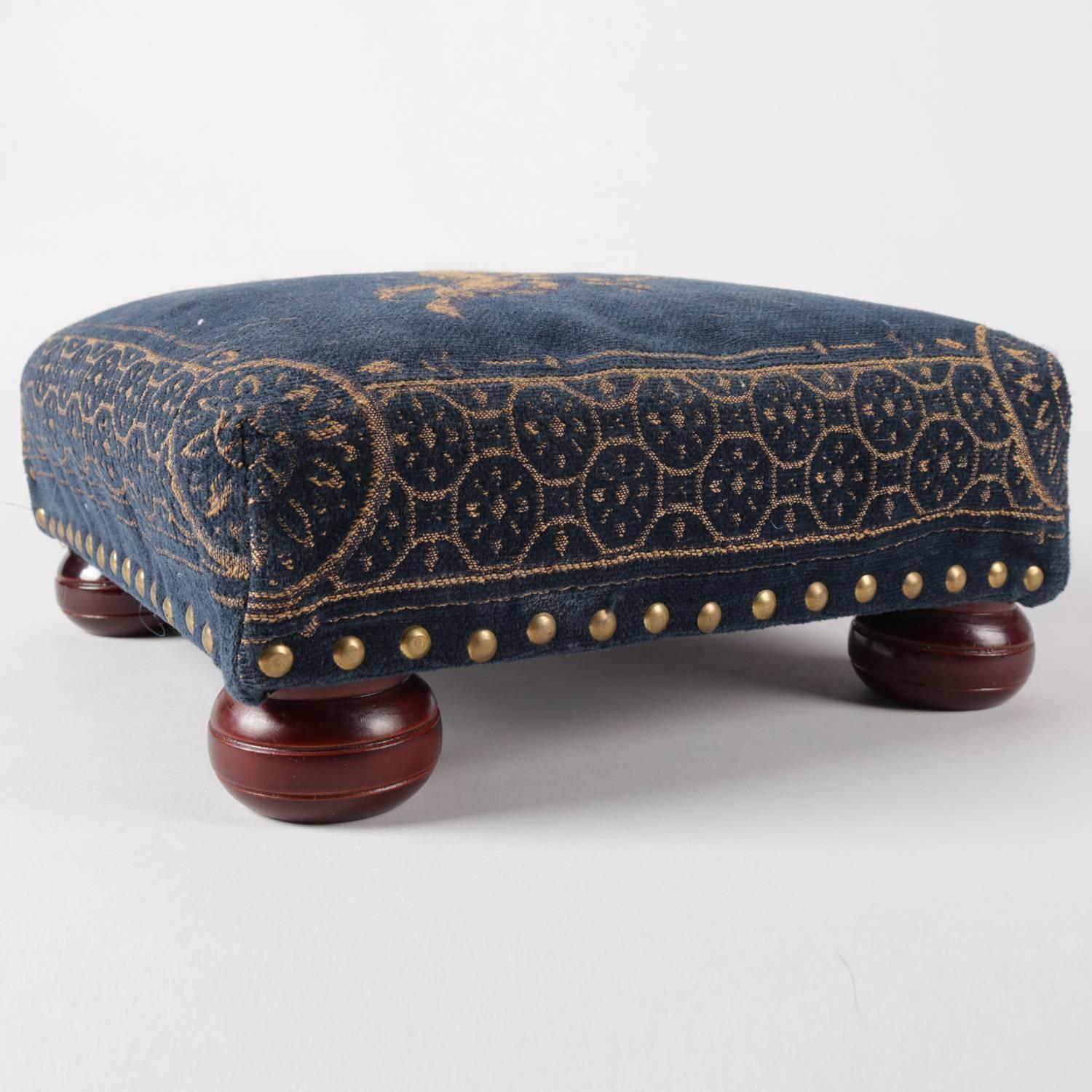 Victorian style footstool features tapestry upper with central cherub, brass tacks, and seated on mahogany ball feet, 20th century.

Measures: 5.5