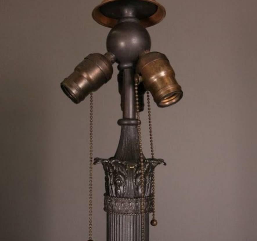 Arts and Crafts antique Wilkinson school floor lamp features bronze base and leaded glass shade, circa 1915.