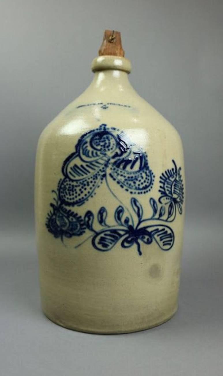 N. Clark Athens blue floral decorated four gallon stoneware jug made in Athens, New York by N. Clark Pottery, features traditional stoneware color with sharp blue foliate design. This particular jug is rare due to its size and beautiful floral