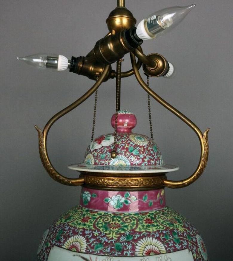 Fine large porcelain Chinese Famille Rose urn lamp features an enamel painted porcelain covered jar mounted with gilt bronze and brass hardware with acanthus leaves and double “S” socket cluster, circa 1910. Measures: Approximate 29