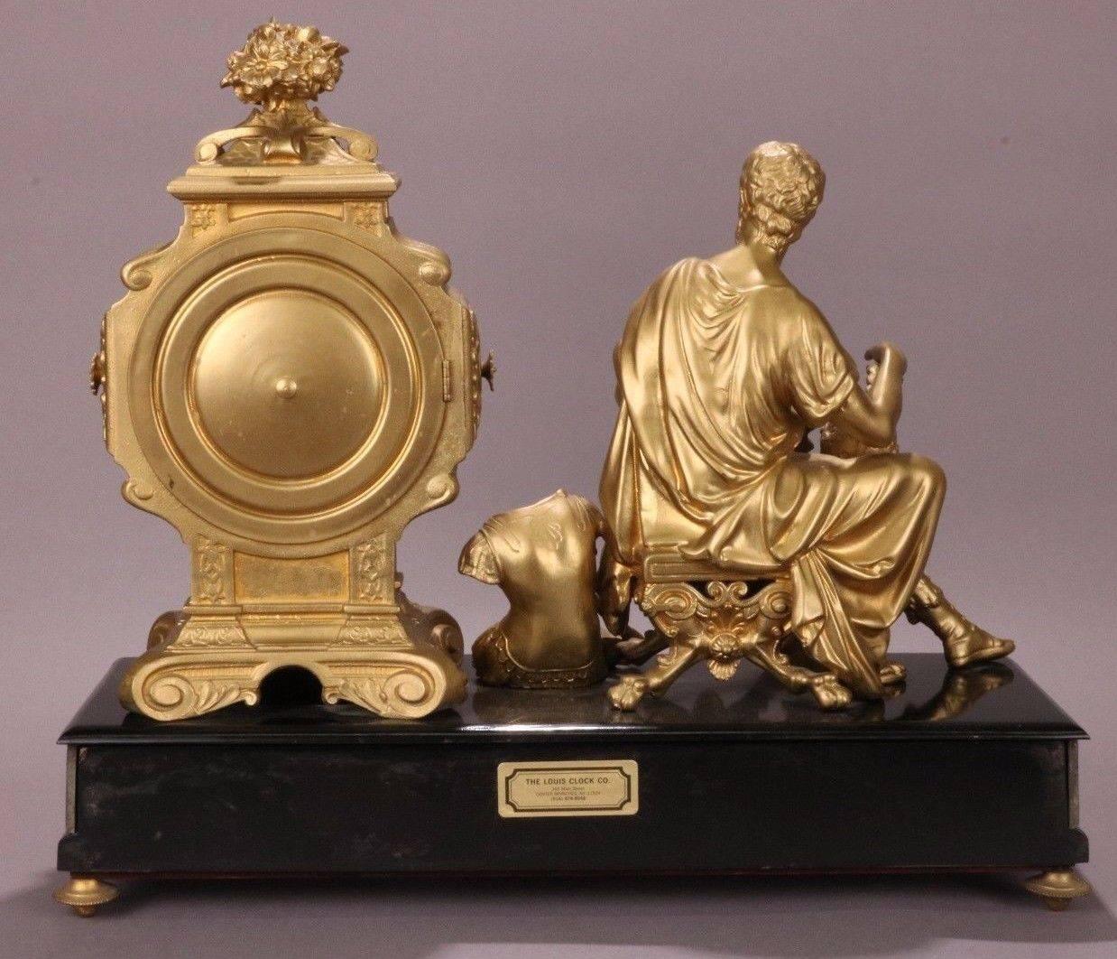 Elegant antique Ansonia bronzed white metal mantel clock features a stunning classical male seated with armor, sword, and helmet, circa 1880. Exposed gears on face of clock create a beautiful aesthetic. Finish is a gilt bronze on white metal.