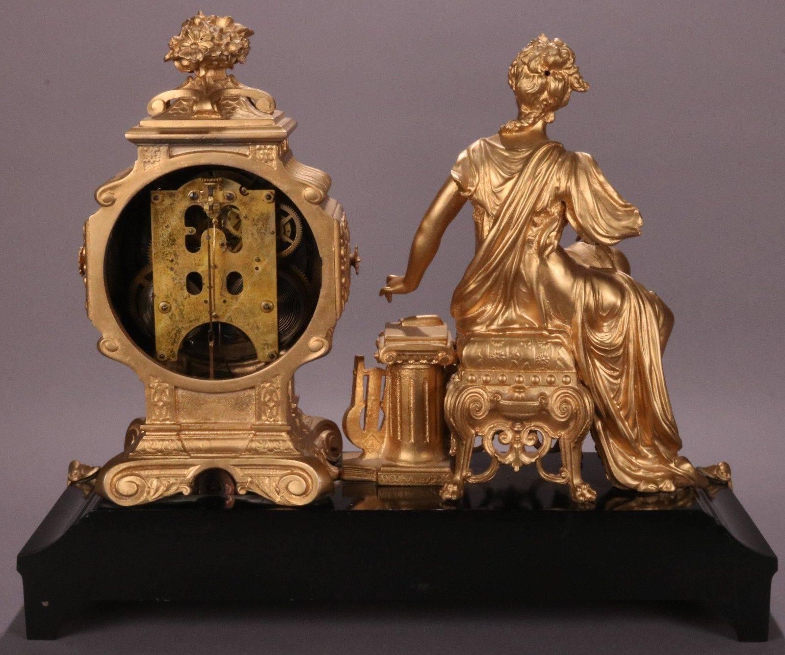 Elegant antique bronzed white metal Ansonia mantel clock features a stunning classical woman seated beside a list of playwrights and philosophers, lyre, and drama mask associated with Greek Muses, each highly detailed and crisp, circa 1880. Finish