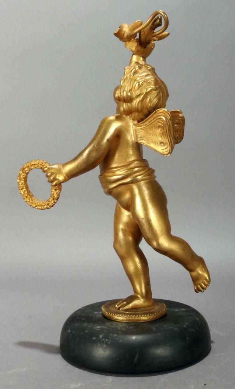 Classical antique figural gilt bronze cabinet statue features cherub with wreath and olive branch a top marble base, circa 1890.