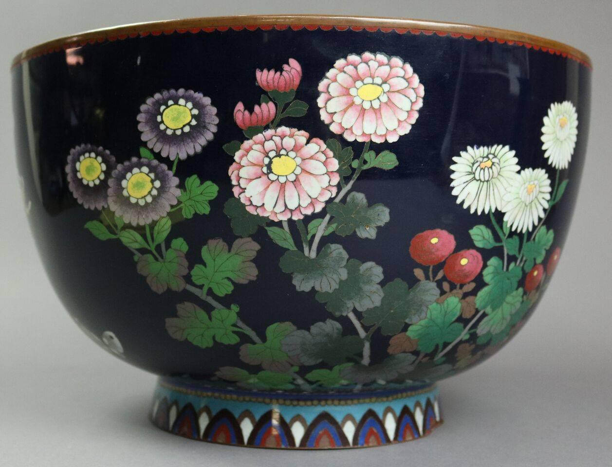 Oversized antique Japanese jardiniere of Meiji period features cloisonne enameled floral garden scene done in the Anglo-Japanese aesthetic, early 20th century.