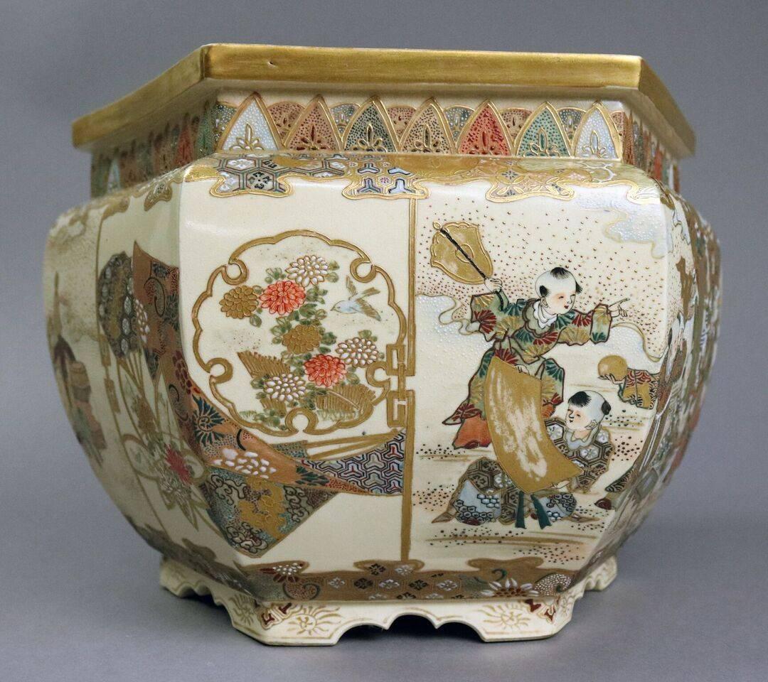 Antique hexagonal hand-painted Satsuma jardiniere features village scenes in moriage and gold gilt decoration, late 19th century.