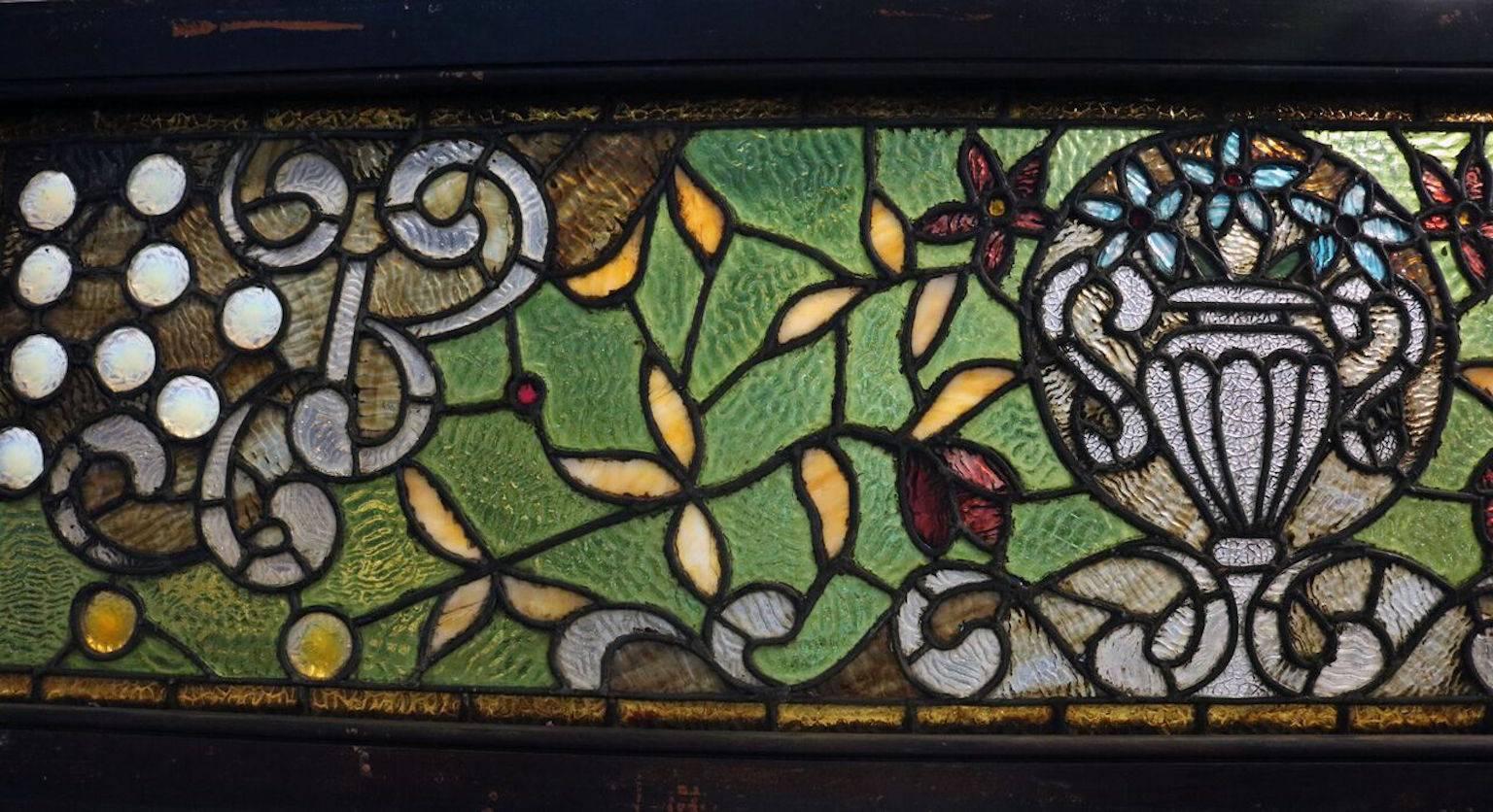 Antique Tiffany LaFarge style window features floral urn design includes chunk jewel and leaded ripple stained glass, late 19th century.