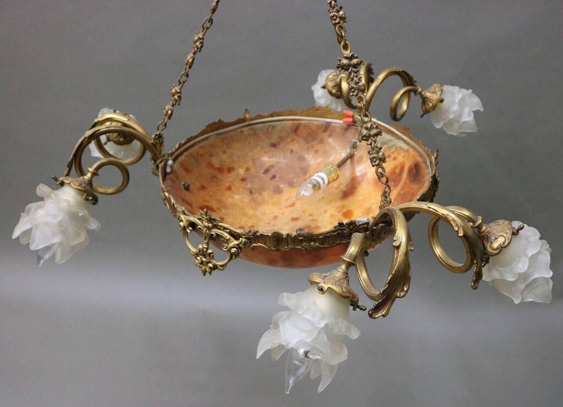 French chandelier features foliate and scrolled bronze frame with six arms, Daum Nancy style glass bowl, and replacement opaque shades, late 19th century.