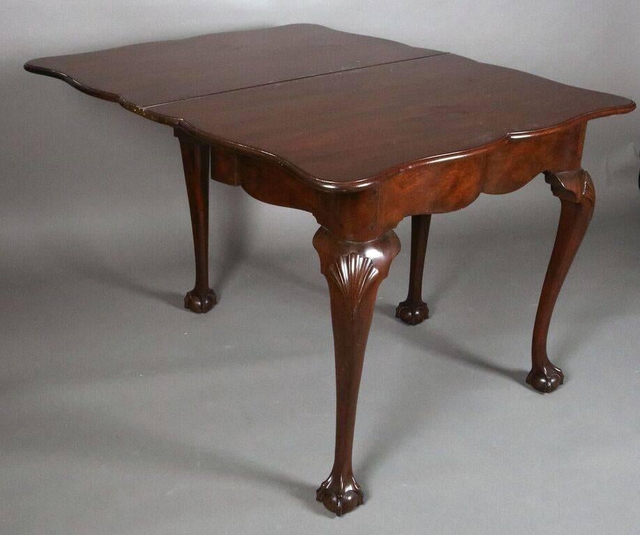 Kittinger mahogany game table features Classic Chippendale cabriole legs with carved shell knees terminating in claw and ball feet, signed, early 20th century.
Top measures 38" x 23" (closed) or 38" x 46" (open).