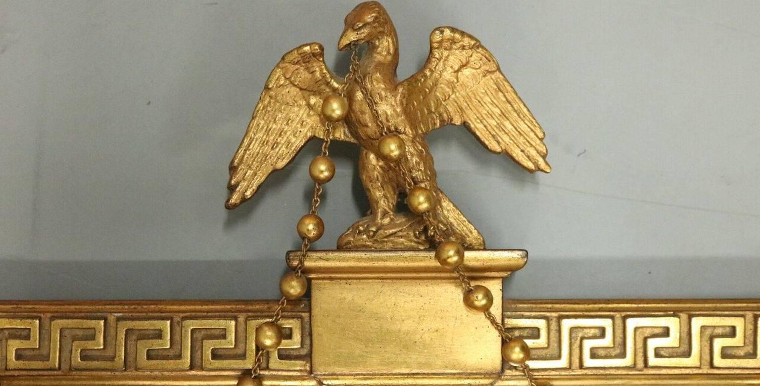 Vintage federal style wall mirror features Greek key bordering terminating in corner rosettes, topped by a spread eagle, and bears the Borghese maker's label en verso, circa 1930.

Measures: 40.5" H x 23.75" W x 2.75" D.