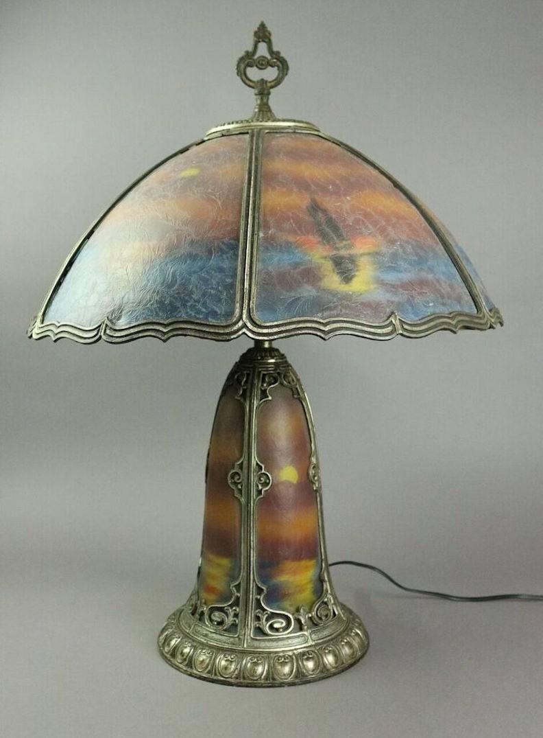 Antique reverse painted Pittsburgh style bronze six-panel double light table lamp depicts seascape scene, circa 1920.