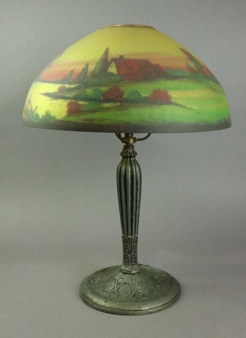 Antique hand-painted Pittsburgh style Jefferson table lamp features cast base and reverse painted shade with countryside scene, signed Jefferson, early 20th century.