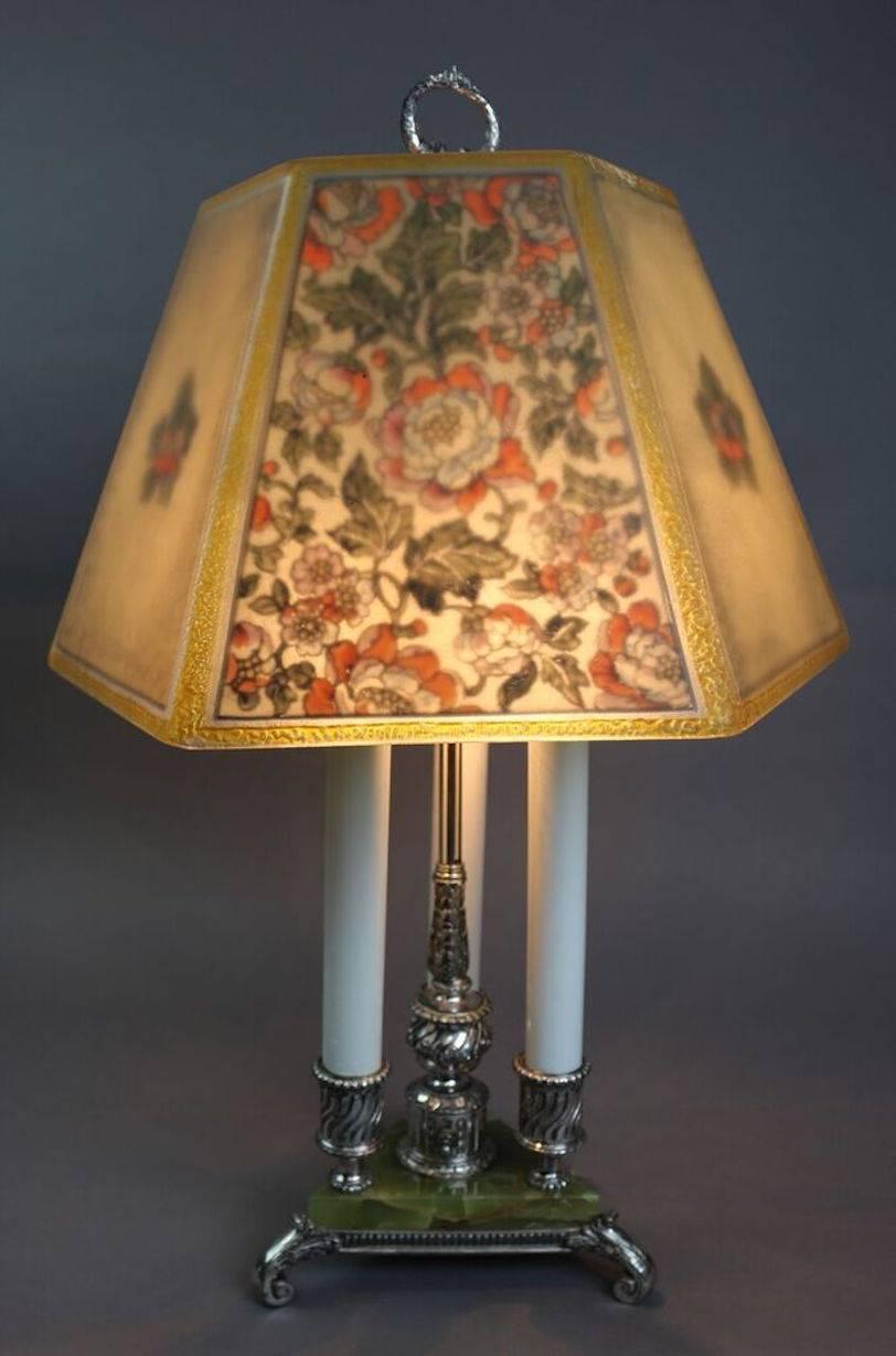 Antique pairpoint bouillotte lamp features hand-painted floral hexagonal shade with alternating all-over and medallion floral patterned panels atop the original three light triangular silver plate and variegated green marble tripod base with scroll
