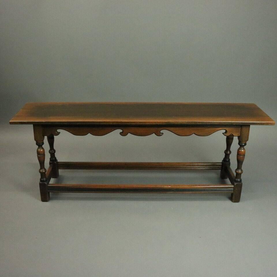 Pair antique long benches feature walnut construction including turned legs and scalloped aprons beneath platform topped with cushions, metal tag Kittinger, Buffalo, NY, circa 1930.

Measures: 19" H x 52.5 W x 12.5" D x 52.5" long.